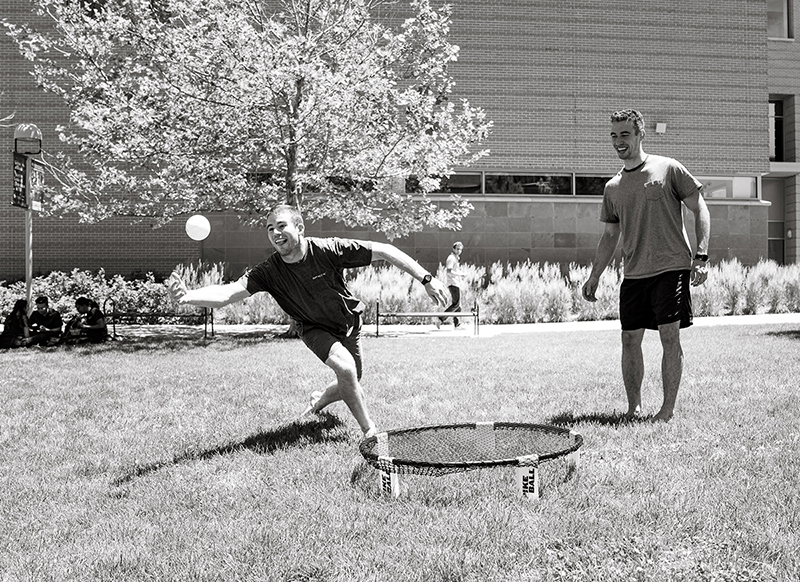 Students playing spikeball black and white
