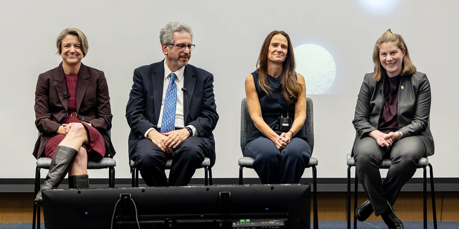 Dr. Amanda Piquet and three other panelists speaking at a conference
