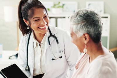 Woman smiling and talking with doctor