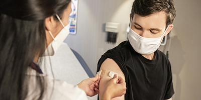 man getting a bandaid after a vaccine