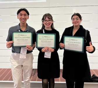 Three people holding certificates