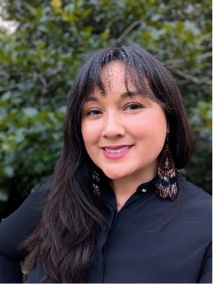 woman with black hair and bangs in a black shirt with dangling earrings