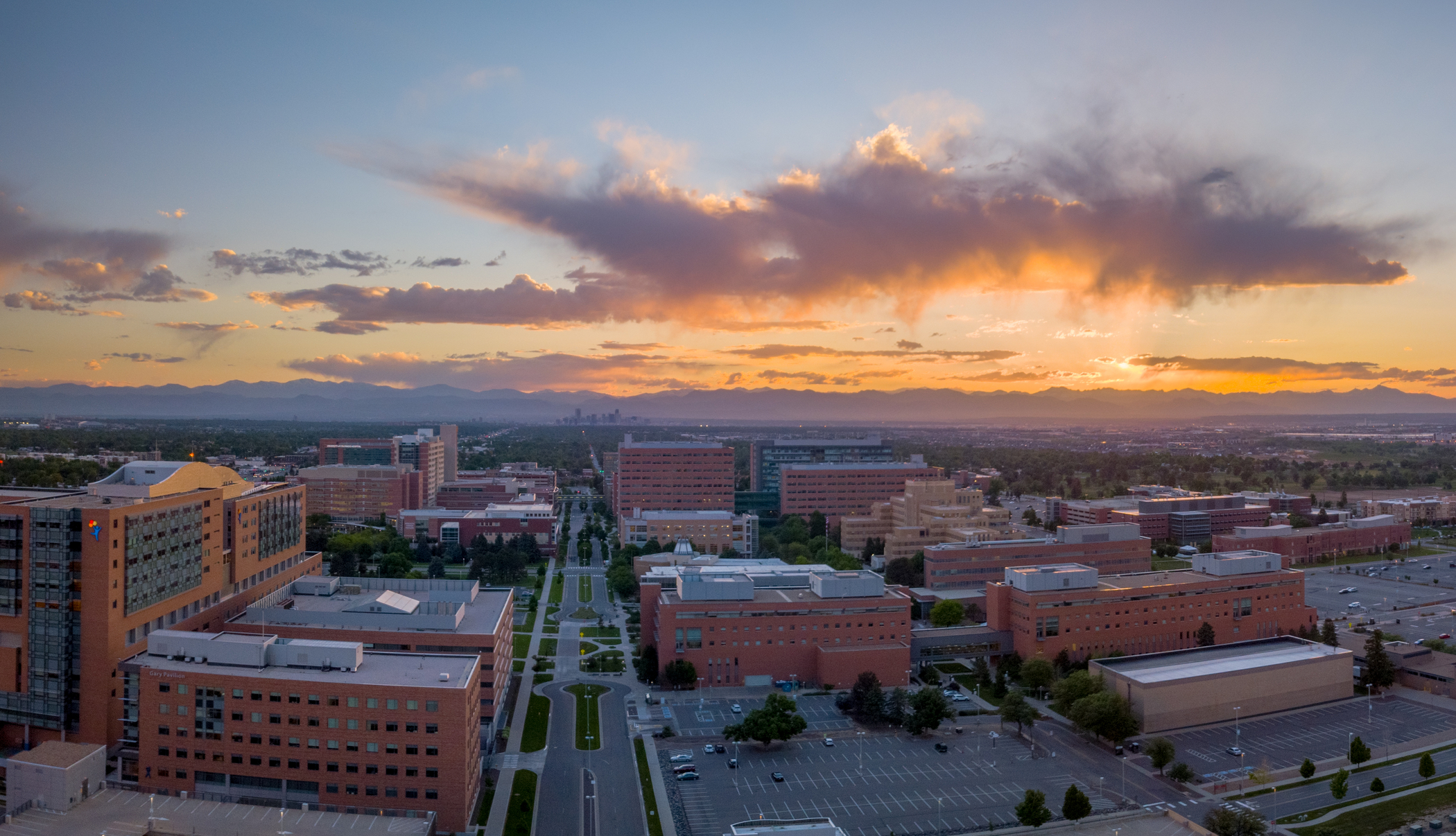 Ariel photo of the CU Anschutz Campus with the rocky mountains and a sunset in the back