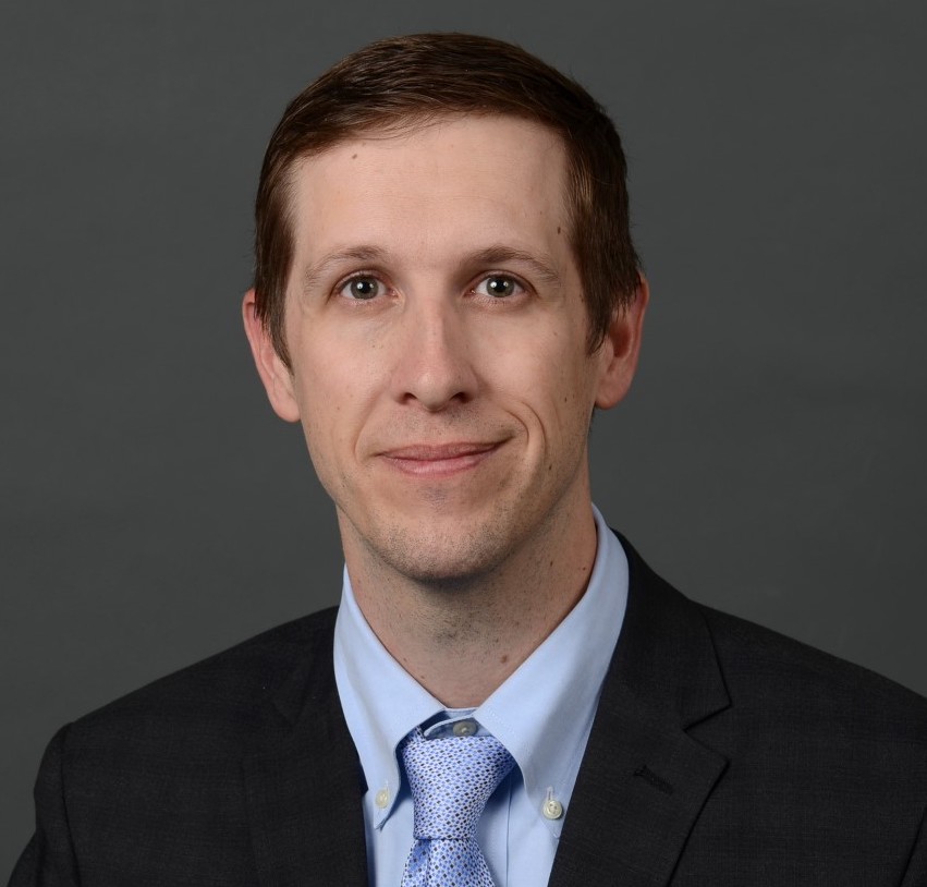 Grant Osborne smiling, wearing a black suit and blue tie