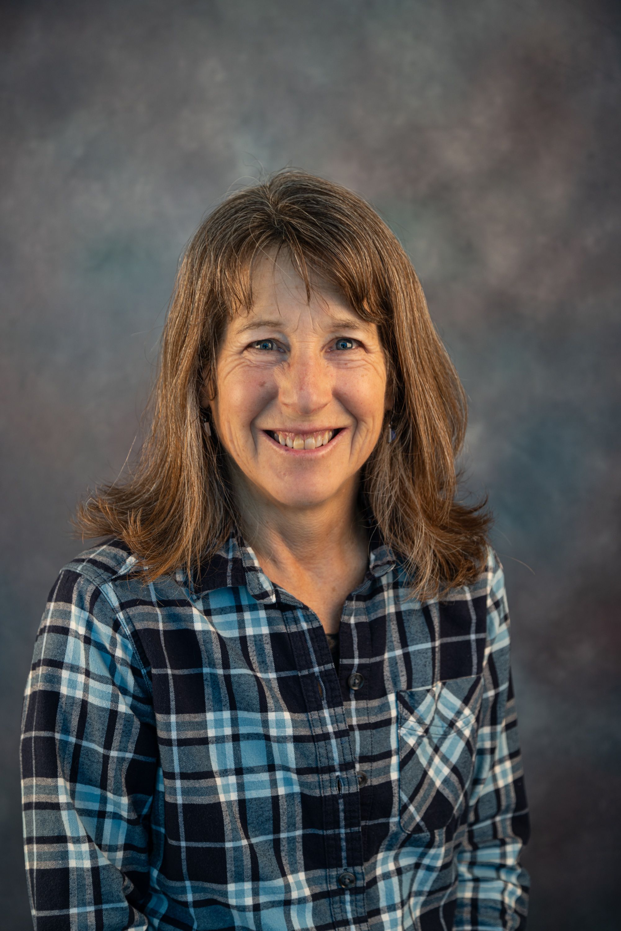 Photo for Julie Lanh, PhD, wearing a blue plaid button shirt.
