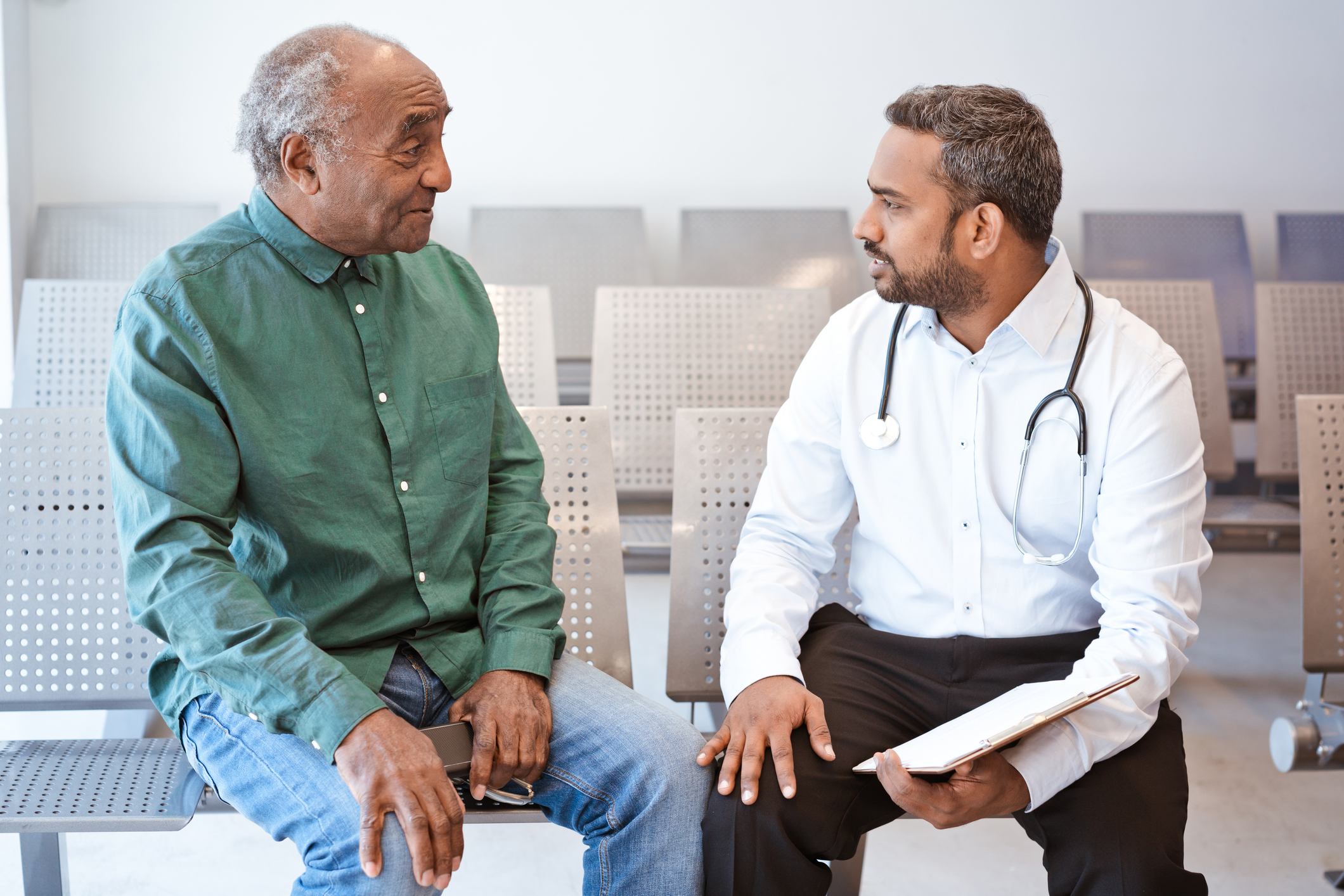 Elderly African American man has conversation with his younger physician