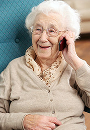 Elderly woman smiling, talking on phone