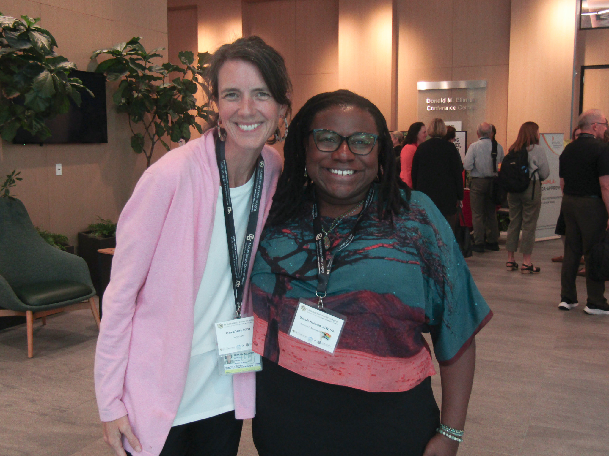 Two conference-goers pose together.