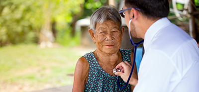 doctor listening to a patient's heart in an outdoor clinic