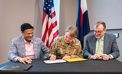 Col. Vik Bebarta, MD, Brig. Gen. Linell Letendre, and former CU School of Medicine Dean John J. Reilly, Jr., MD, signing a partnership agreement