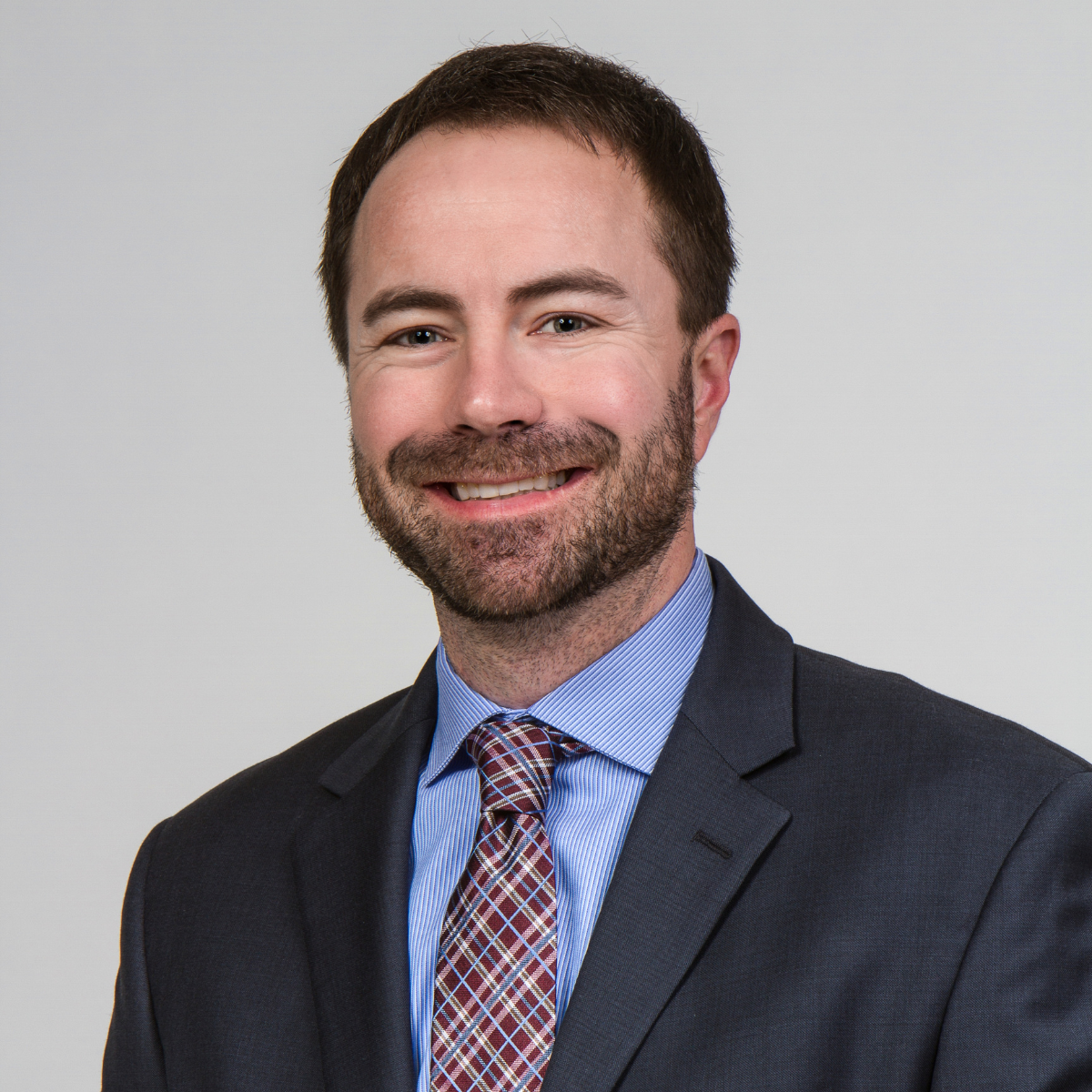 Doctorwithcheckeredtieandbeardsmiling