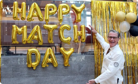DeanSampsoninfrontofgoldballoonsspellingHappyMatchDay