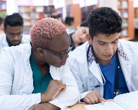 Two students reviewing a case in a book