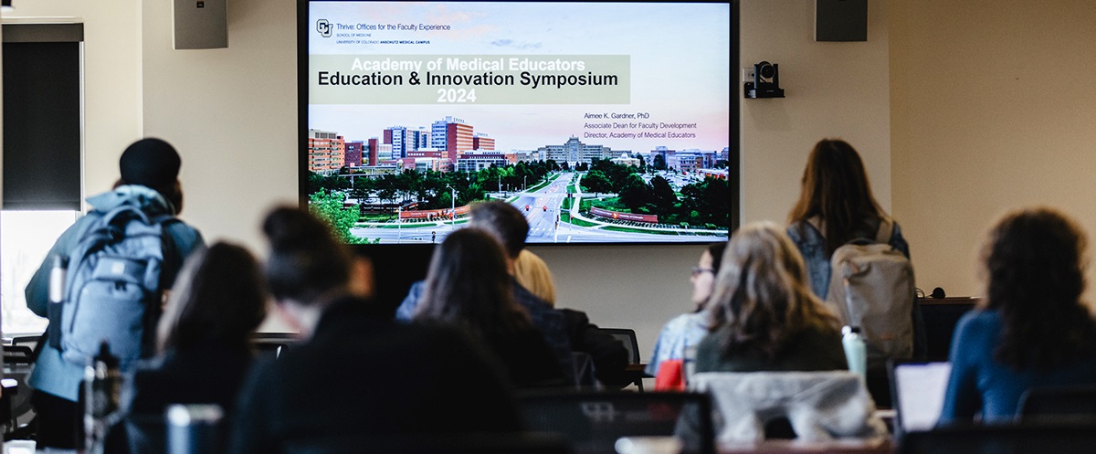 Studentsandfacultyinclassroomwatchingasymposiumpresentation