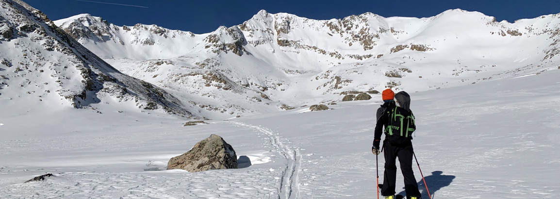 CU medical student Michael Nocek skiing Triple Rock. Mountains, blue sky and snow. 