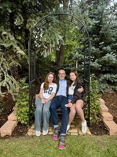 Rosscambridgeanddaughtersseatedinagarden