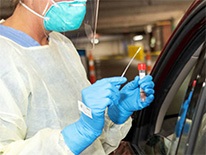 healthworkerpreparingtestforCOVID-19outsidecarwindow