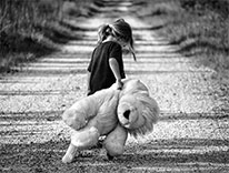 child hauling a big teddy bear