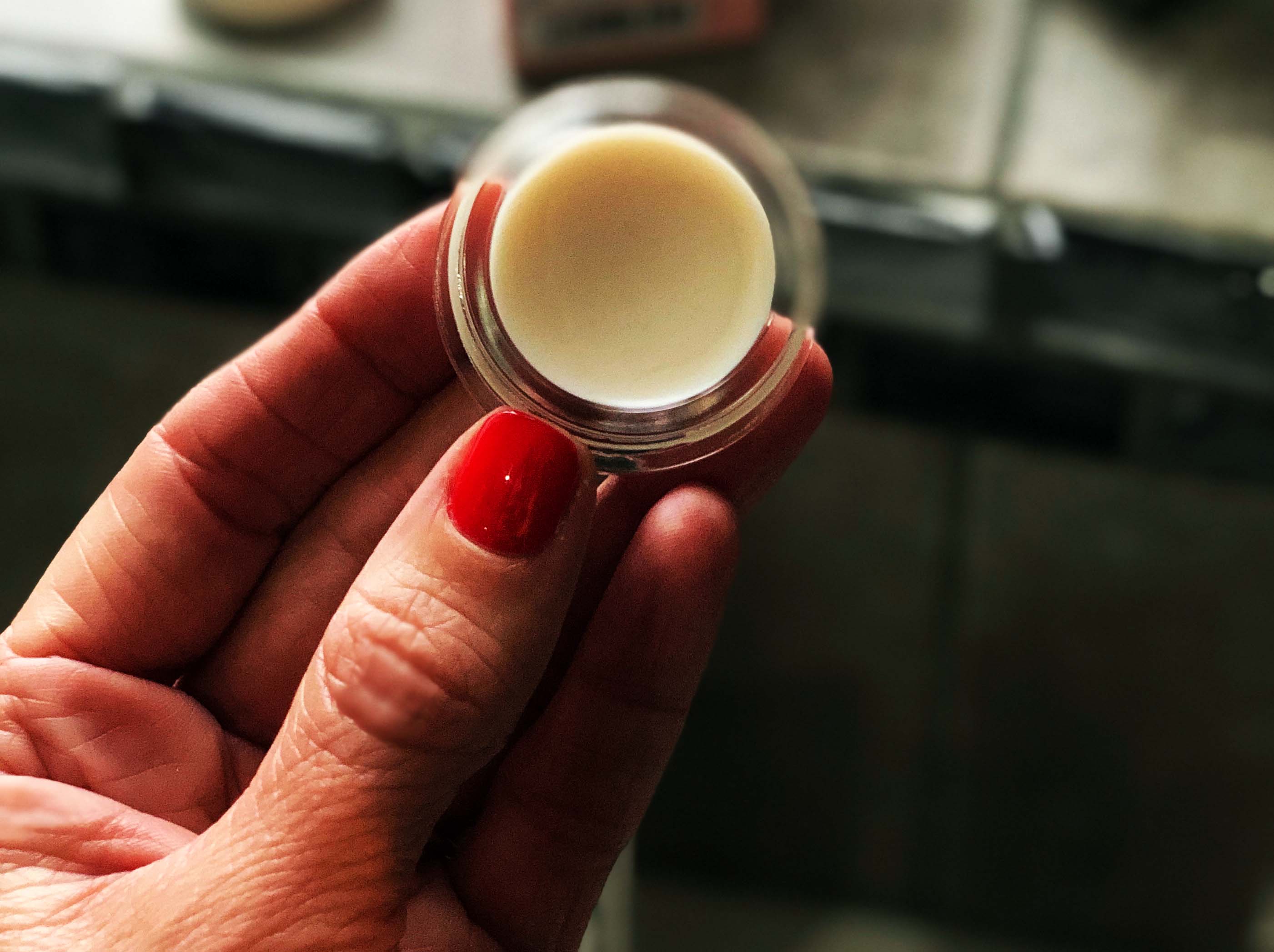 pot of lotion in a hand