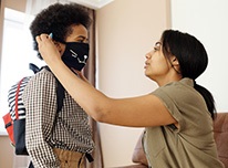 Momputsmaskonchildwearingbackpack