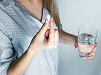 Woman taking pills with a glass of water