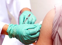 healthcareworkergivingshotinarmtopatientwithsleeverolledup