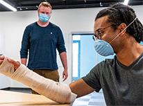 studentwatchinganotherstudentwithcastonarm