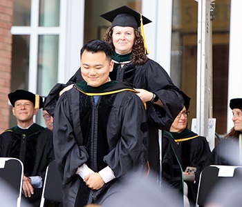 Studentbeinghoodedonstage