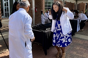 Matriculantwithstethoscopewearingwhitecoatonstagewithfacultymember