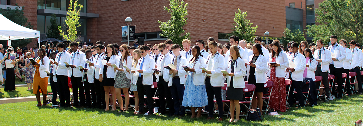 matriculation ceremony showing students standing in quad