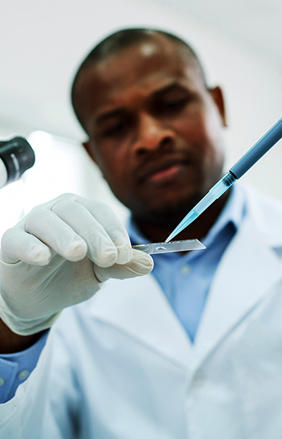 researcher in white coat with syringe