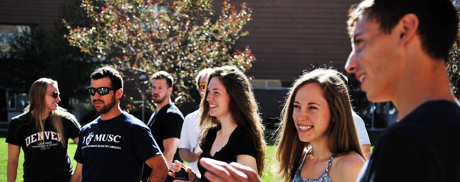 Studentslaughingsmilingstandinginthequadsinsunshine
