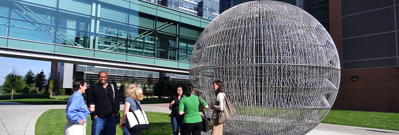 Studentsoncampusnearbigwiresculptureandglasswalkway
