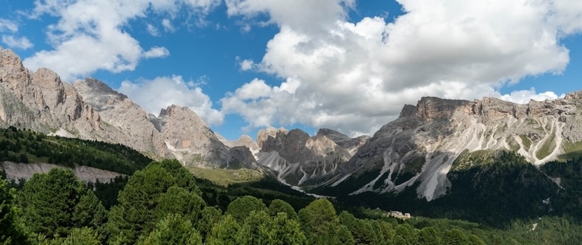 Mountainpeaksandforestwithcloudysky