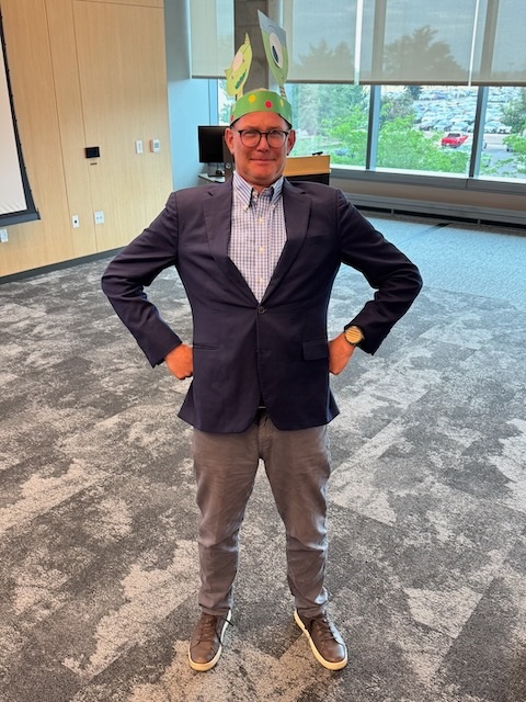 DxExfacultywearingmonstertrophyhatposinglikeasuperhero