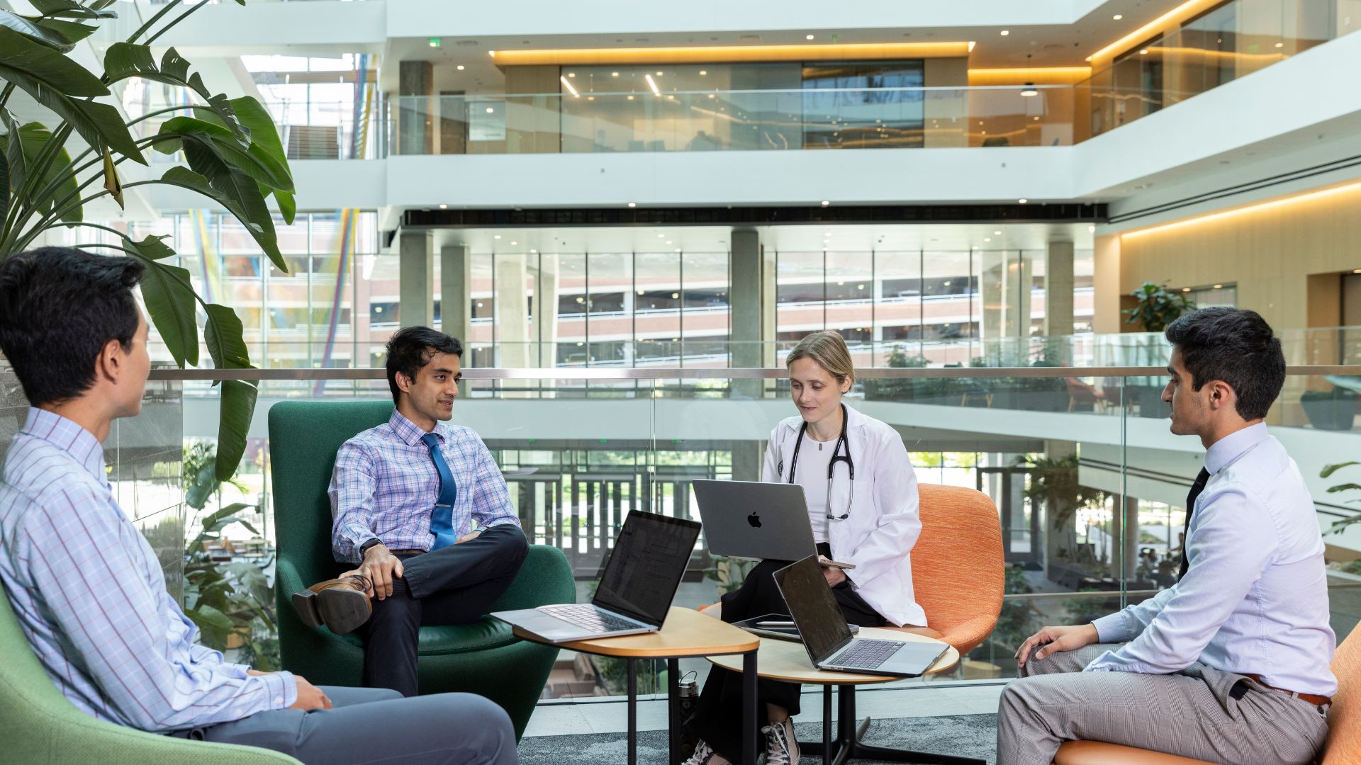 Doctorssittinginarelaxedareacollaboratingwiththeirlaptops