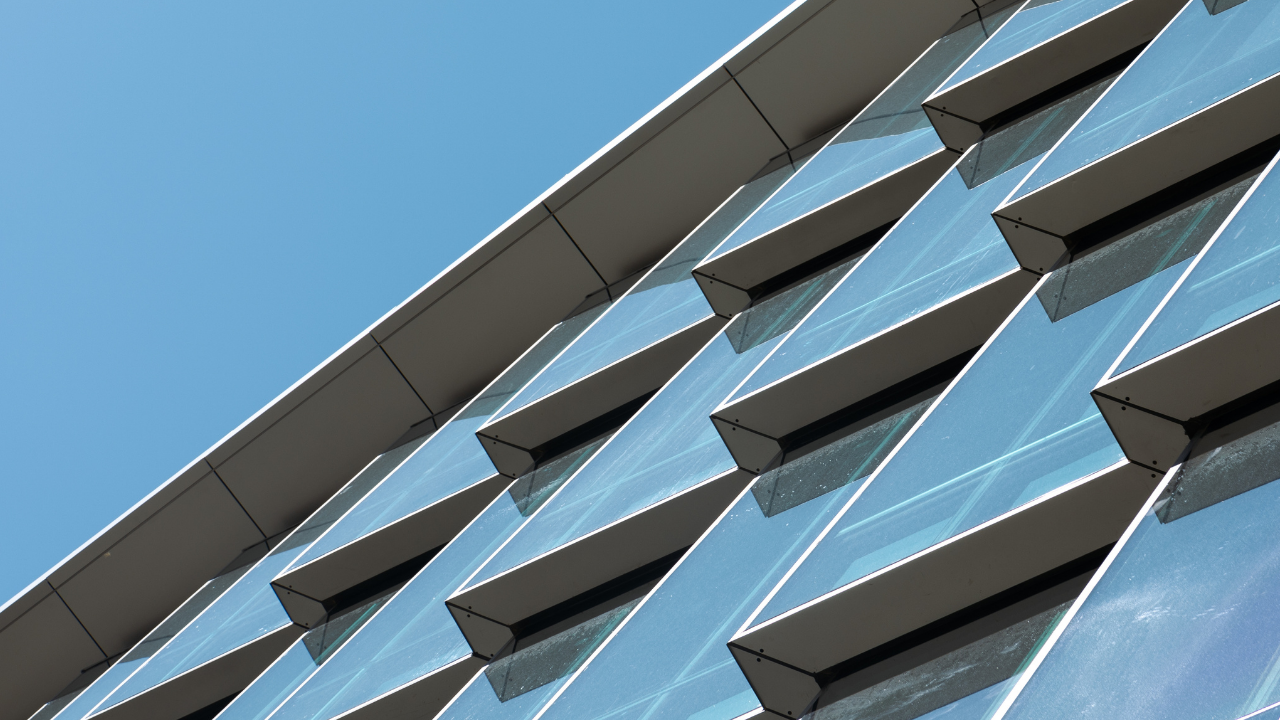 Closeupofglasswindowsreflectingthebluesky