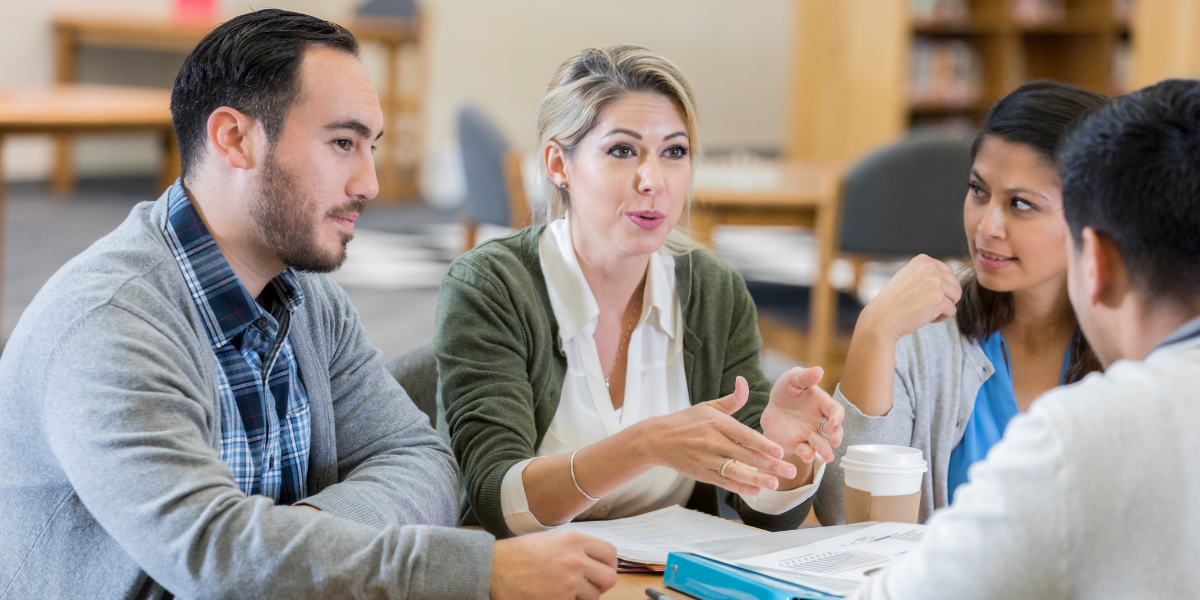 grouphasanengagingdiscussionataroundtableinthelibrary