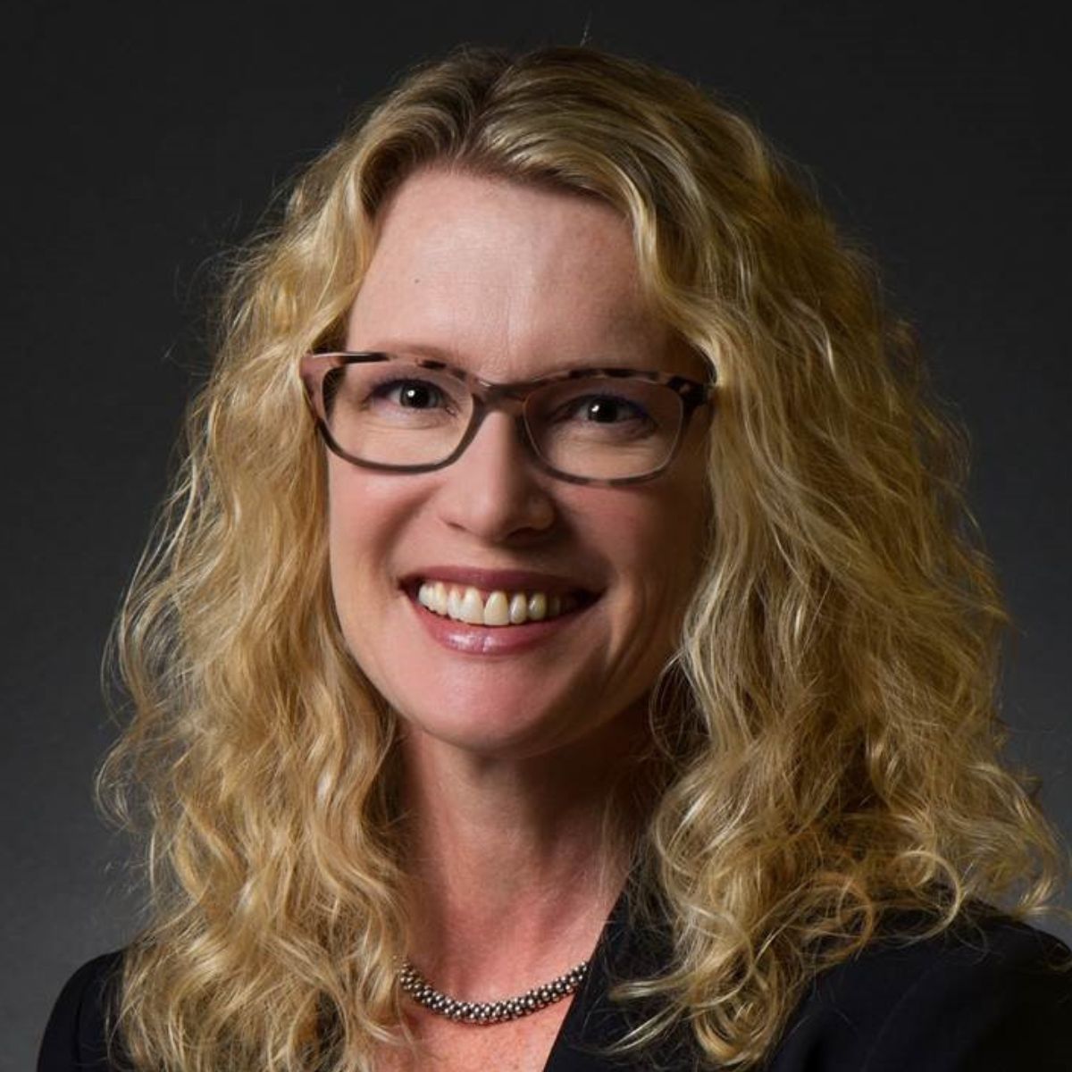 womanwithcurlyhairandblacksuitjacket