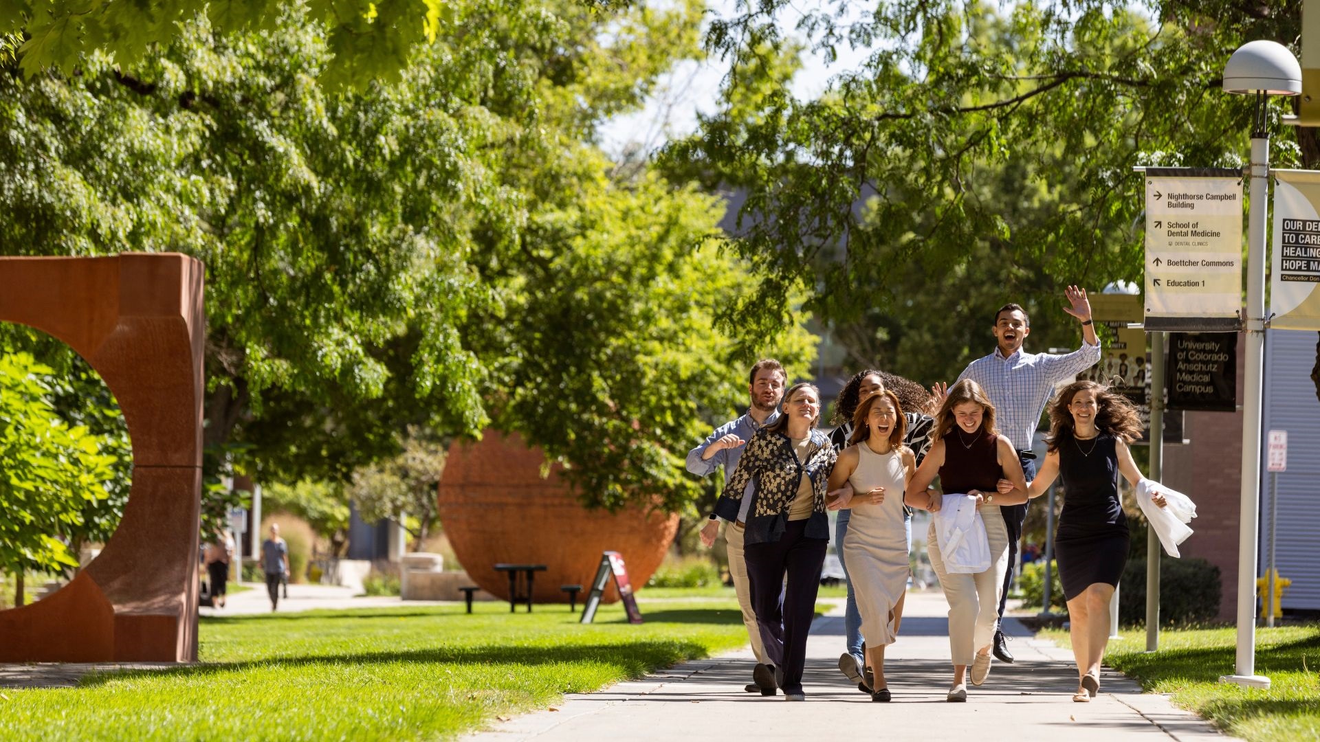 Groupofstudentscelebratingontree-lineswalkway
