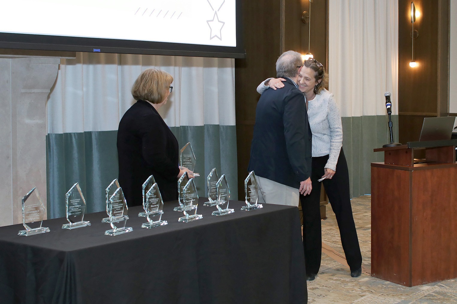 onepersonbeinghugedbyotherrecievinganaward