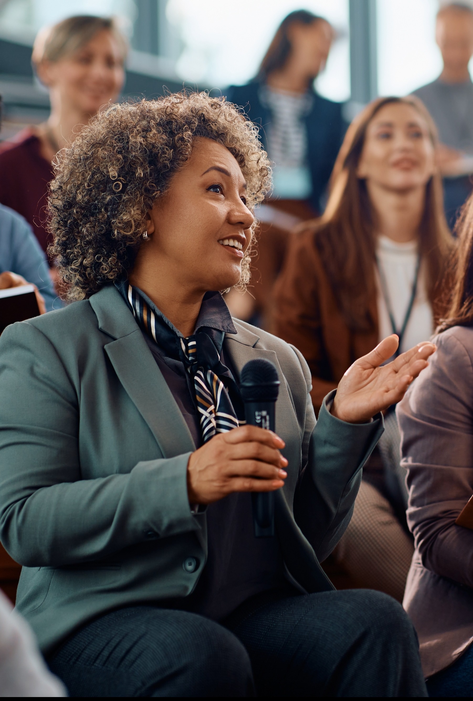 Membersinanaudiencewithonememberholdingmicrophoneandspeaking