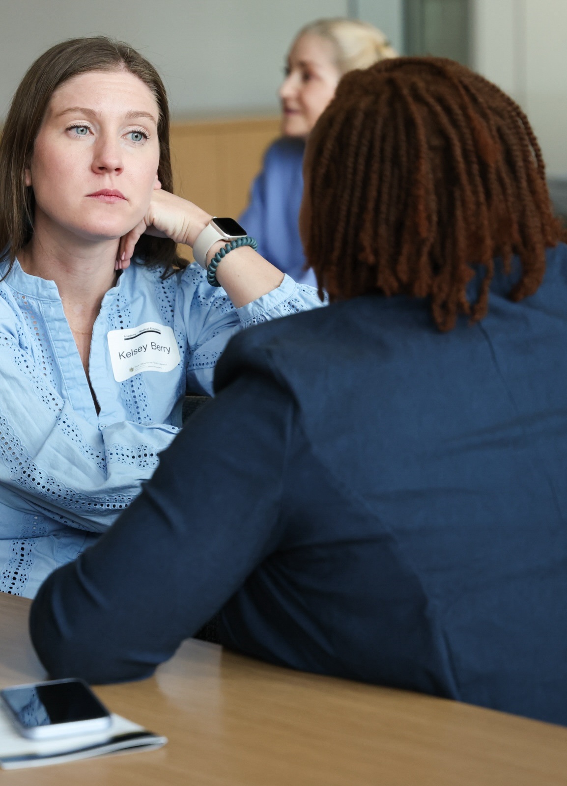 Personsittingatatableandlisteningtoanotherperson