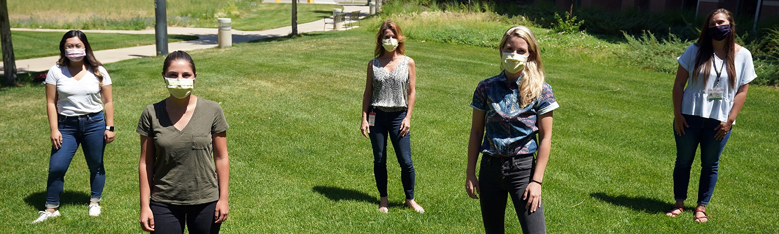 studentswearingmasksstandingongrasssixfeetapart