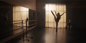 A ballet dancer silhouetted in front of a window.