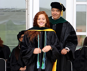 graduateonstagegettinghooded