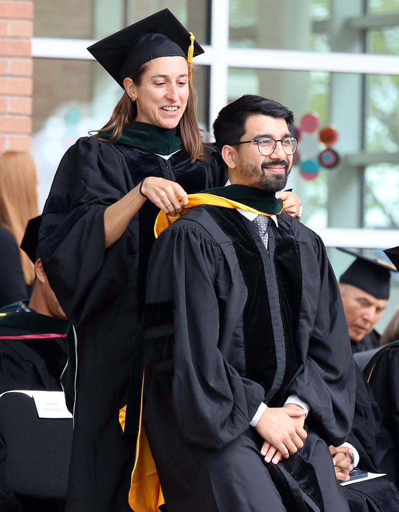 graduatebeinghoodedonstage