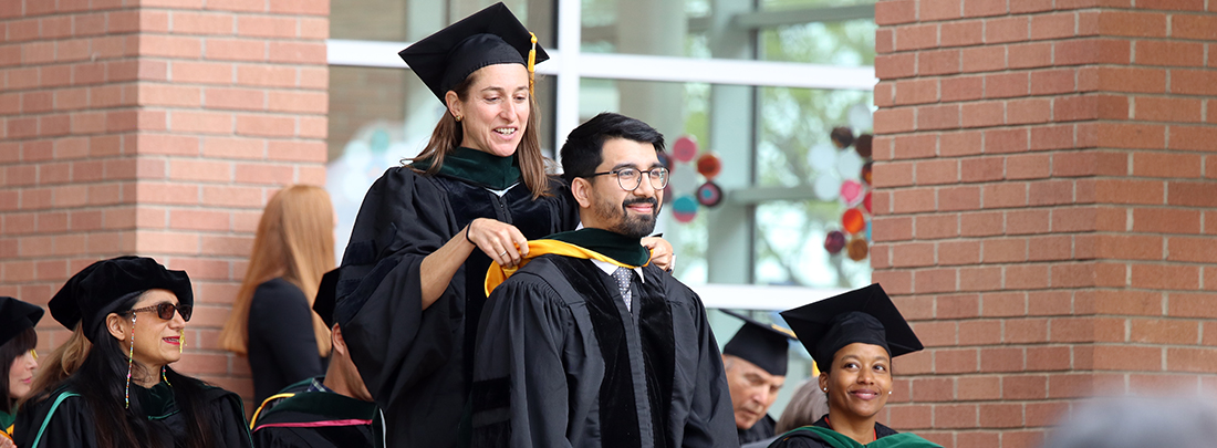 graduatebeinghoodedonstage