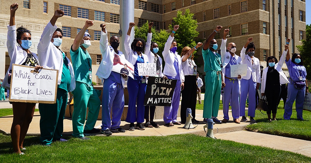 studentsgatheredfistsraisedcarryingsignsoncampus
