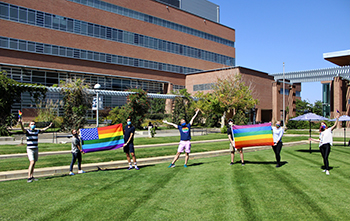 MSPA members holding pride flags on the Boettcher Commons lawn on campus